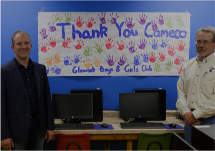 An image of two people standing in front of a thank you cameco sign