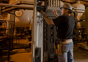 An employee inspecting facility equipment